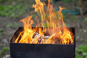 Burning wood in an open charcoal grill