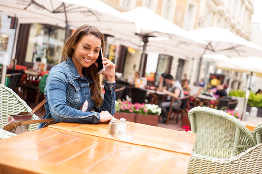 young woman talking on the phone at a restaurant