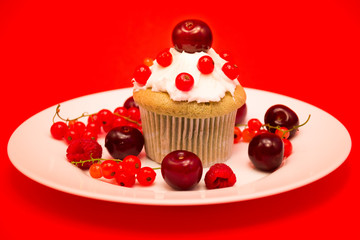 Sweet cupcake with berries and cherries