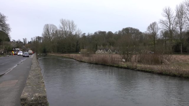Cottswold England road maintenance along riverHistorical village with homes businesses. Cotswolds, Area of Outstanding Natural Beauty (AONB) rolling hills and rivers. Destination for tourism