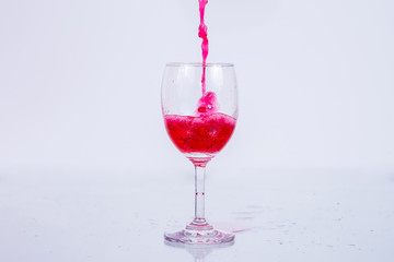Red wine splash on white background.