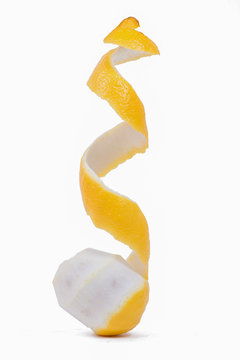 Yellow lemon with peeled skin on white background.