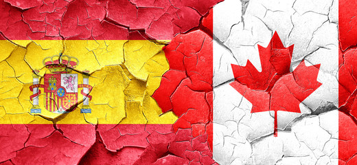 Spanish flag with Canada flag on a grunge cracked wall