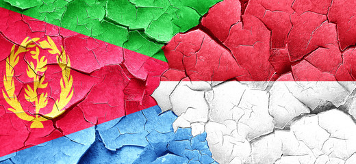 Eritrea flag with Indonesia flag on a grunge cracked wall