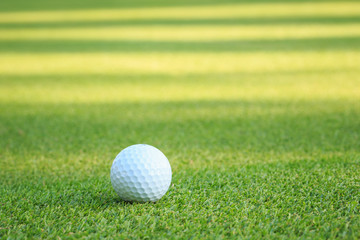 Golf ball on green grass in course