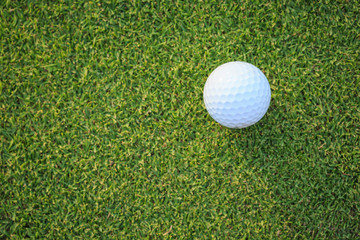 Golf ball on green grass in course