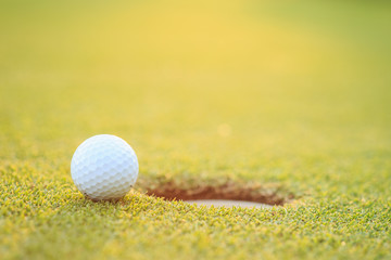 Golf ball on lip of cup  in course