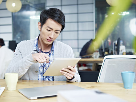 young asian business person using tablet working in office