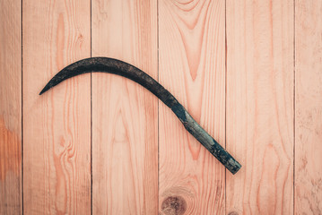 Sickle on wooden floor