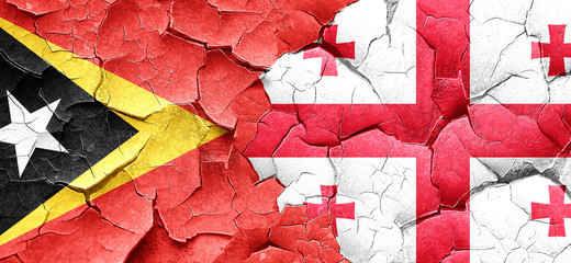 east timor flag with Georgia flag on a grunge cracked wall