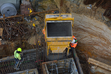 Construction site worker during concrete pouring into formwork