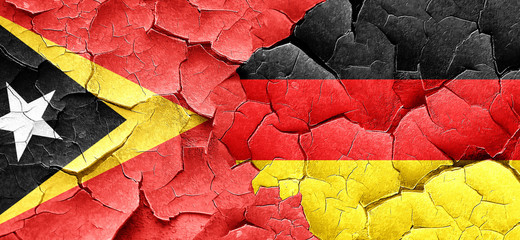 east timor flag with Germany flag on a grunge cracked wall