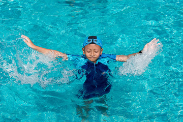 Young boy swimming in pool