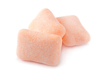 Peach color chewing gum piece on white