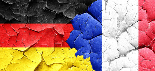 German flag with France flag on a grunge cracked wall