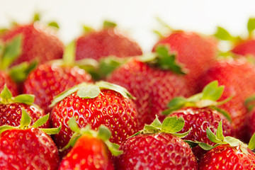 Strawberry background of whole strawberries in sunlight.  Colorful ripe berries  strawberries. Fruit background. Strawberry pattern. Spring background. Summer background. Top view. Macro. Texture.