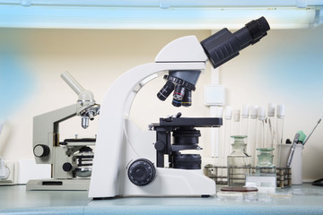 Photo of a professional ocular laboratory microscope with stereo eyepiece in laboratory interior.