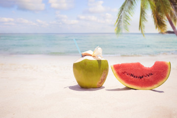 Summer fruit concept with coconut cocktial, watermelon on sandy tropical beach
