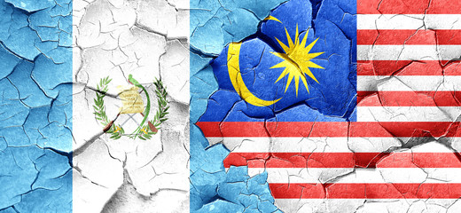 guatemala flag with Malaysia flag on a grunge cracked wall