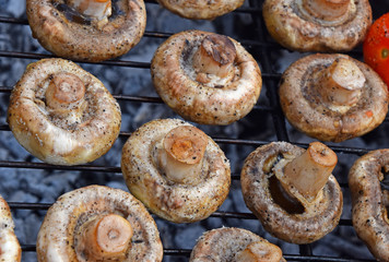 White champignons mushrooms on grill