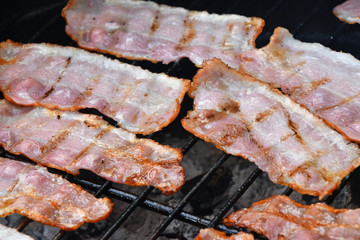 Crispy smoked bacon slices cooked on bbq grill