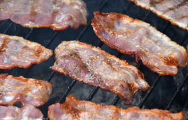Crispy smoked bacon slices cooked on bbq grill