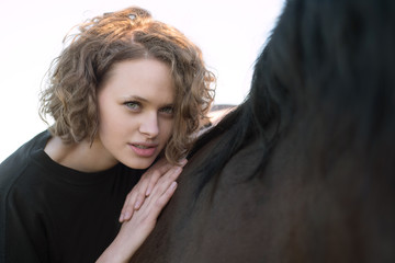 Beautiful young woman with a horse outdoor.