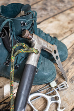Handmade ice axe with old boots on wood background