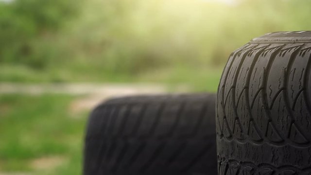 Close up of obsolete used car tires with blur traffic in background