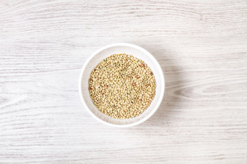 Lentejas verdes dentro de un cuenco blanco sobre un fondo de madera rústico. Vista superior. Copy space