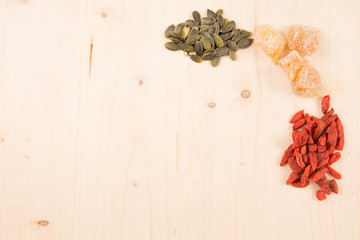 Goji berries, seeds, coffee, ginger, wooden table with copy space