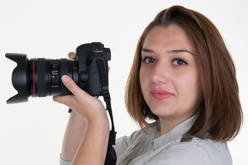 Woman takes images holding photographic camera, isolated on a white