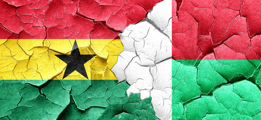 Ghana flag with Madagascar flag on a grunge cracked wall