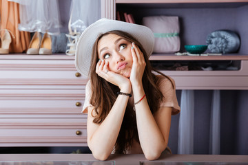 Beautiful young woman thinking about something in her closet