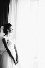 The bride standing  near window
