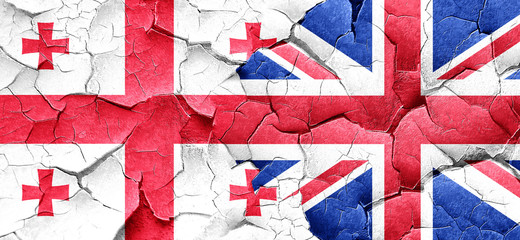 Georgia flag with Great Britain flag on a grunge cracked wall