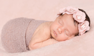 newborn cute girl sleeping on a pink background