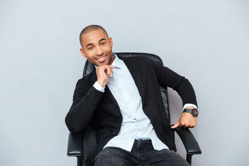 Confident smiling african american young man sitting in office chair