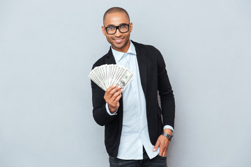 Cheerful african american young man standing and holding money