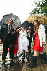 Fototapeta na wymiar Newlyweds have fun posing with friends in the gumboots