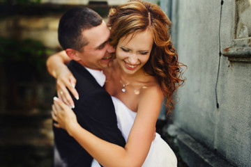 Obraz na płótnie Canvas Fiance hugs tightly a smiling bride