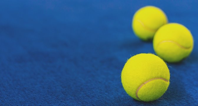 Tennisbälle auf blauem Court.