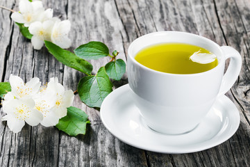 Fototapeta na wymiar a cup of jasmine tea with jasmine flowers , close-up