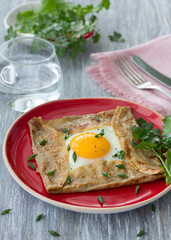 Homemade buckwheat pancakes with egg and cheese on the wooden table, selective focus