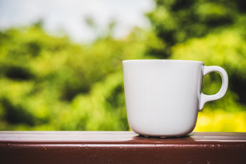 Cup of coffee on steel table and nature background