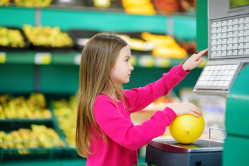 Fototapeta premium Cute little girl shopping in a food store