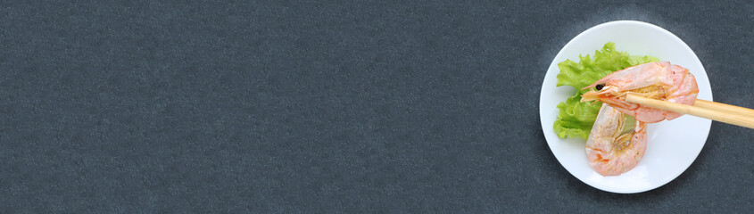 Assiette de crevettes et baguettes chinoises sur ardoise, carte, menu, bannière