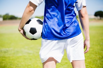 Obraz premium Mid-section of soccer player standing with a ball