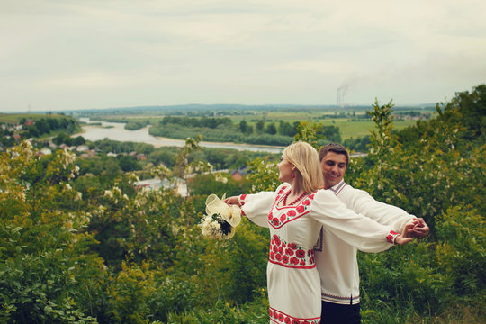 Bride and groom spread their hands leaning to each other on the