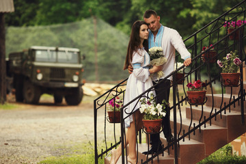 Wedding couple dressed in Ukrainian ethnic style stands on the s